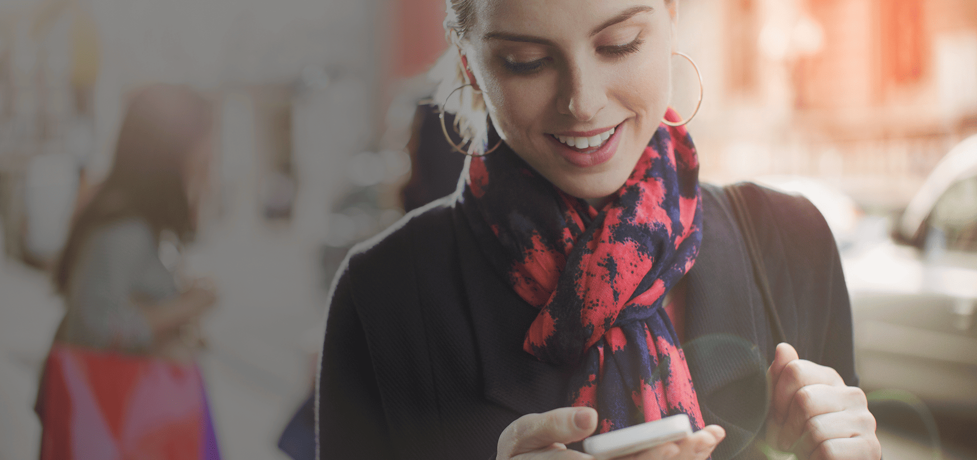 Bild einer Frau die mit dem Priority Pass der Mastercard Platinum Zugang zu exklusiven Flughafenlounges weltweit über ihr Handy erhält.